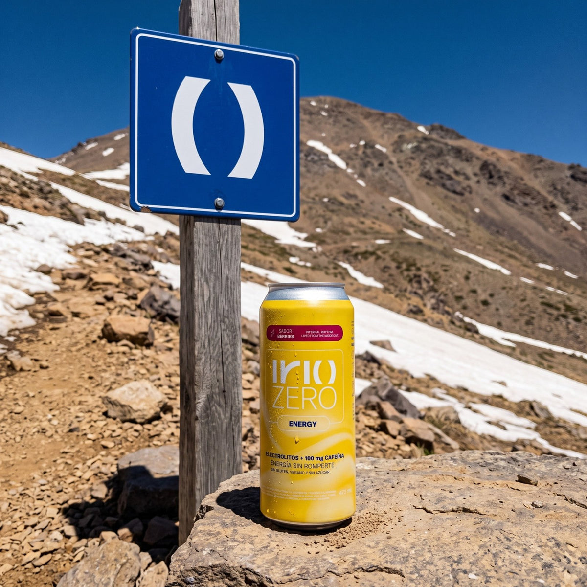 Lata de Irio ZERO Energy Berries junto a un cartel azul de Irio en un sendero de Farellones